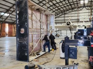 Technician performing LED sign repair at commercial building