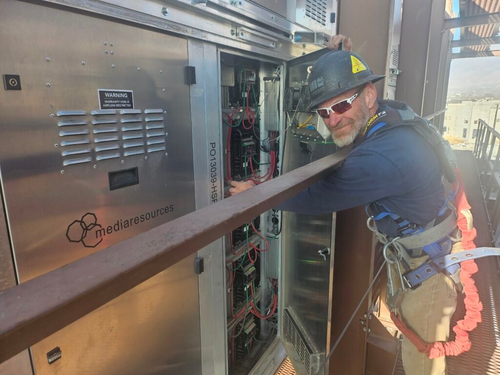 Man on sign working on electronics